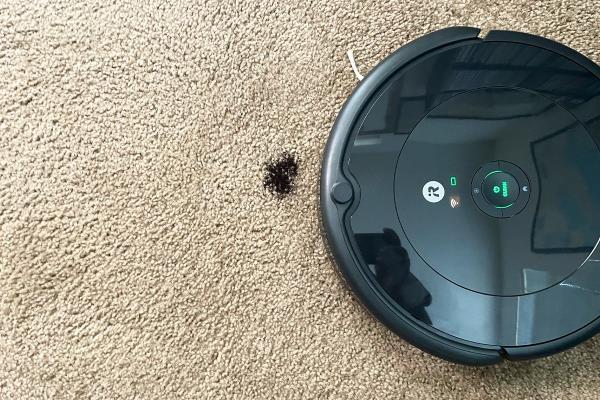 Roomba 692 Robot Vacuum on carpet navigating toward debris