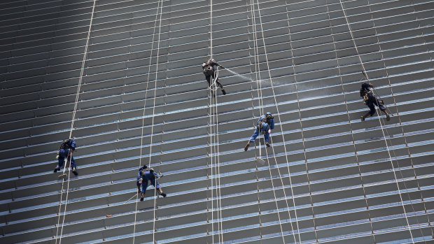 Workers clean the exterior of an office building in Singapore. The island-nation is well-known for its strict regulations regarding cleanliness and crime.