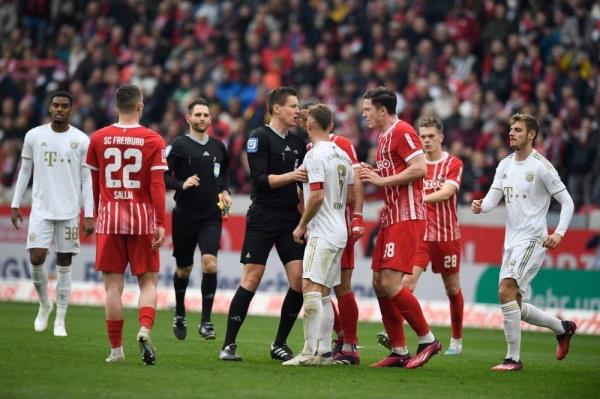 The referee has word with Bayern Munich's German midfielder Joshua Kimmich and Freiburg's Austrian forward Michael Gregoritsch during the German first division Bundesliga football match between SC Freiburg and Bayern Munich in Freiburg on April 8. - Pic: AFP