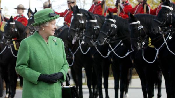 Queen Elizabeth II views members of the Royal Canadian Mounted Police Musical Ride, upon her arrival at the forces' Equestrian Centre in Ottawa, October 14, 2002.